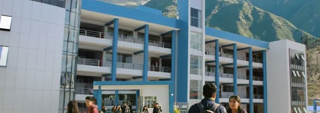 Fachada exterior del edificio de la Facultad de Educación y Ciencia Política de la UNAMBA en Apurímac, sede del Museo Interactivo Micaela Bastidas, con montañas andinas de fondo